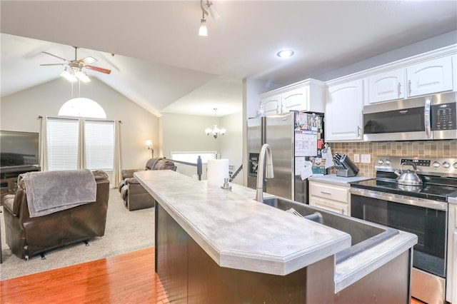 1215 Nottingham Dr, Warrensburg, MO 64093 - kitchen featuring open floor plan, white cabinetry, ceiling fan with notable chandelier, a wealth of natural light, and stainless steel appliances