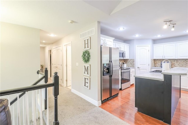 1215 Nottingham Dr, Warrensburg, MO 64093 - kitchen featuring backsplash, visible vents, appliances with stainless steel finishes, light countertops, and white cabinets