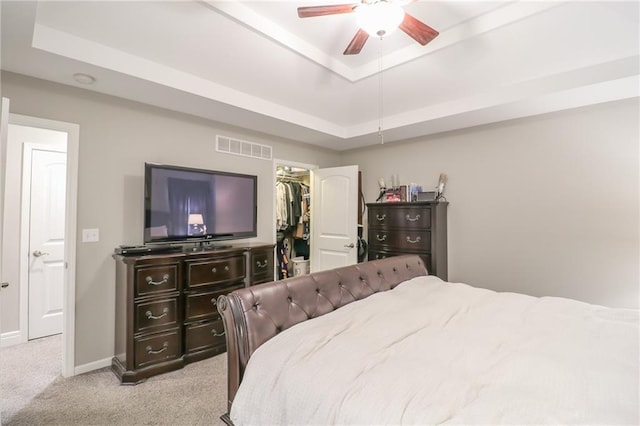 1215 Nottingham Dr, Warrensburg, MO 64093 - bedroom with visible vents, light carpet, baseboards, a walk in closet, and a raised ceiling