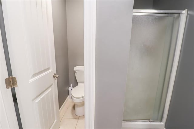 1215 Nottingham Dr, Warrensburg, MO 64093 - bathroom with toilet, baseboards, tile patterned flooring, and a stall shower
