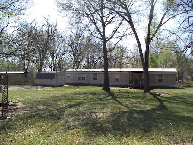 view of yard with a storage unit, an outbuilding, and fence