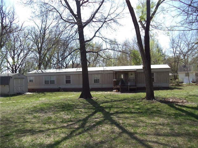 back of house featuring an outbuilding, a yard, and a storage unit