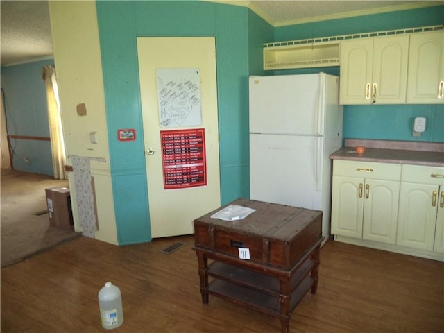 kitchen featuring a textured ceiling, wood finished floors, visible vents, and freestanding refrigerator