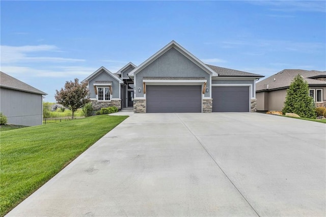 craftsman inspired home featuring an attached garage, a front lawn, driveway, and stone siding