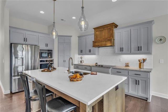 kitchen with appliances with stainless steel finishes, a sink, light countertops, baseboards, and tasteful backsplash