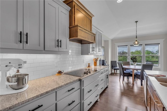 kitchen featuring decorative backsplash, dark wood-style floors, black electric stovetop, and lofted ceiling