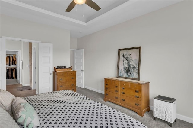 carpeted bedroom featuring baseboards, a ceiling fan, and crown molding