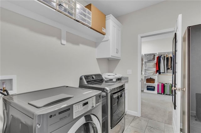 laundry room featuring baseboards, washer and clothes dryer, cabinet space, and light colored carpet