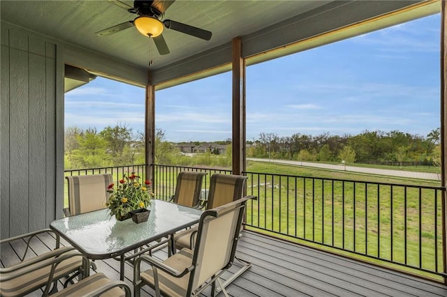sunroom featuring a ceiling fan and outdoor dining space