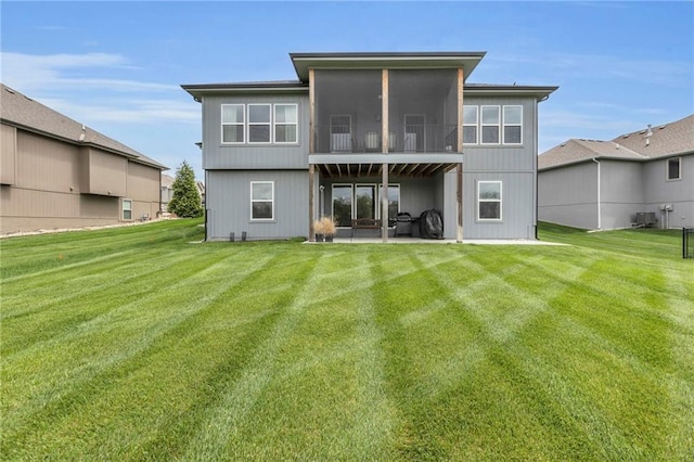back of property featuring a patio, a yard, and a sunroom