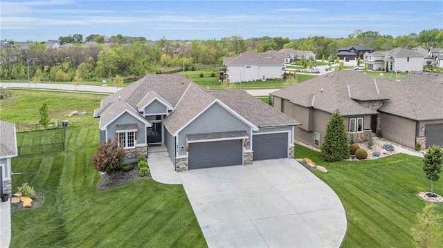 ranch-style house featuring a front yard, concrete driveway, an attached garage, stone siding, and stucco siding