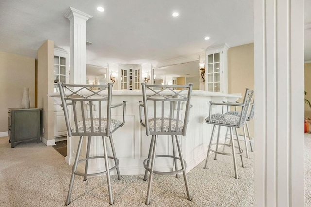 9705 Sunset Cir, Lenexa, KS 66220 - interior space with white cabinets, carpet floors, a breakfast bar, and ornate columns