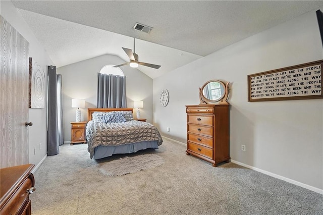 carpeted bedroom with vaulted ceiling, a textured ceiling, ceiling fan, and baseboards