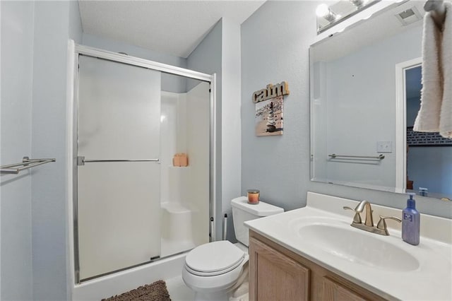 bathroom featuring a shower stall, vanity, and toilet