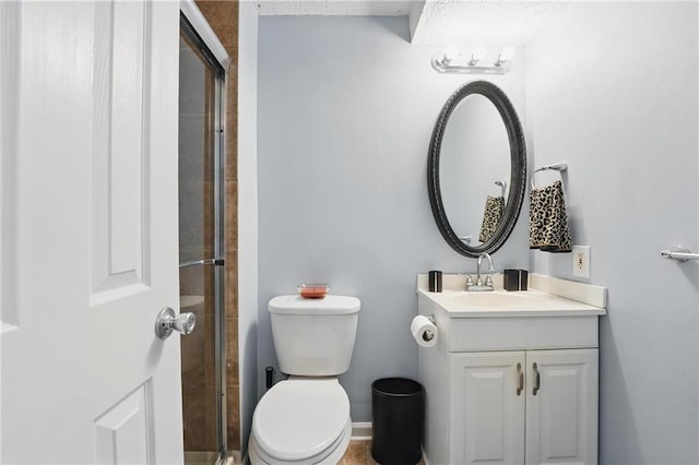 full bathroom with toilet, tiled shower, and vanity