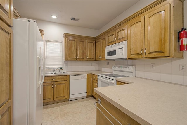 kitchen featuring a sink, brown cabinets, white appliances, visible vents, and light countertops