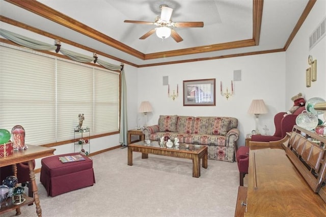 living room featuring carpet, a tray ceiling, visible vents, crown molding, and ceiling fan