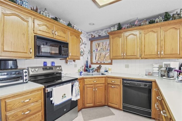 kitchen with tasteful backsplash, a sink, black appliances, a toaster, and light countertops