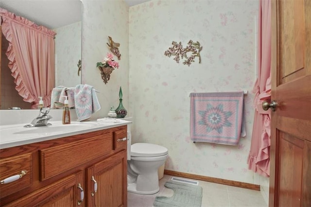 bathroom featuring toilet, baseboards, visible vents, wallpapered walls, and vanity