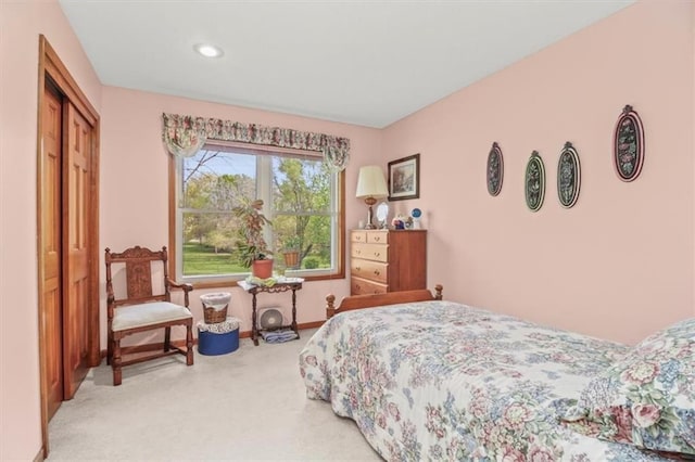 bedroom with recessed lighting, a closet, and light colored carpet