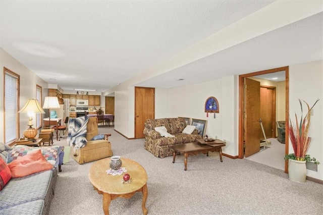 living area featuring light carpet and baseboards