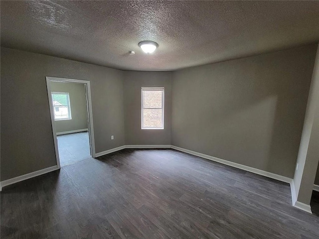 118-148 N Lawn Ave, Kansas City, MO 64123 - spare room featuring baseboards, dark wood-style floors, and a textured ceiling