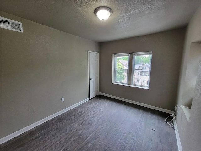 118-148 N Lawn Ave, Kansas City, MO 64123 - spare room with baseboards, visible vents, a textured ceiling, and dark wood-style flooring