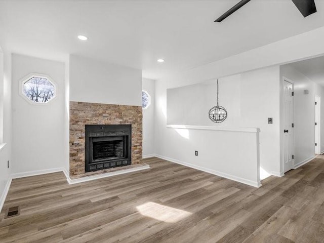 5836 Blue Ridge Blvd, Raytown, MO 64133 - unfurnished living room featuring visible vents, baseboards, recessed lighting, wood finished floors, and a fireplace