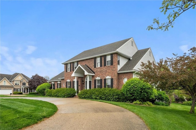 view of front facade featuring brick siding, a shingled roof, and a front lawn