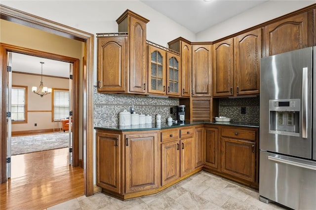 kitchen with tasteful backsplash, a chandelier, dark countertops, and stainless steel fridge with ice dispenser