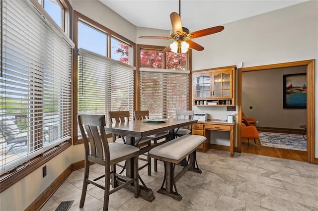 dining area featuring baseboards, plenty of natural light, and ceiling fan