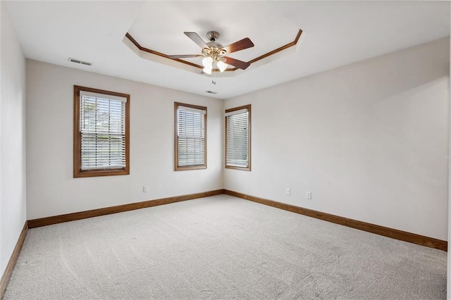 unfurnished room featuring baseboards, carpet, a ceiling fan, and visible vents