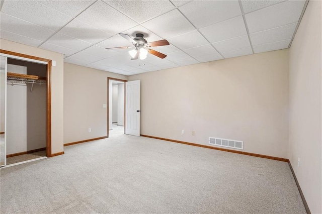 unfurnished bedroom with visible vents, carpet floors, a closet, baseboards, and a paneled ceiling