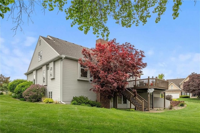 rear view of house featuring stairway, a deck, and a lawn