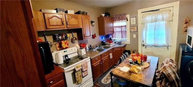 124 W 3rd Ave, Garnett, KS 66032 - kitchen featuring brown cabinets, washer / clothes dryer, a sink, and white appliances