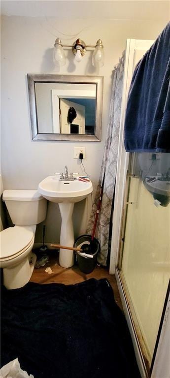 124 W 3rd Ave, Garnett, KS 66032 - bathroom featuring a shower stall, toilet, and a sink