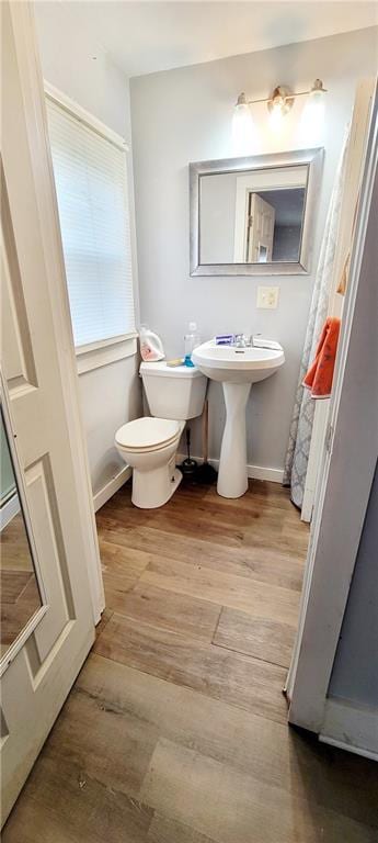 124 W 3rd Ave, Garnett, KS 66032 - bathroom with wood finished floors, toilet, and baseboards