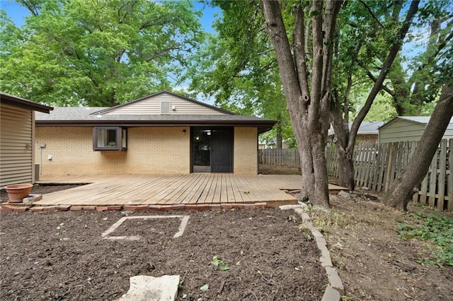 1804 Kenmar Dr, Manhattan, KS 66502 - rear view of house with brick siding, a wooden deck, and uncovered parking