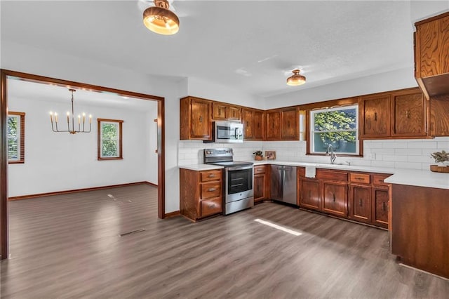 kitchen with appliances with stainless steel finishes, plenty of natural light, and dark wood-style floors