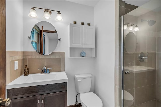 bathroom featuring toilet, a stall shower, and vanity