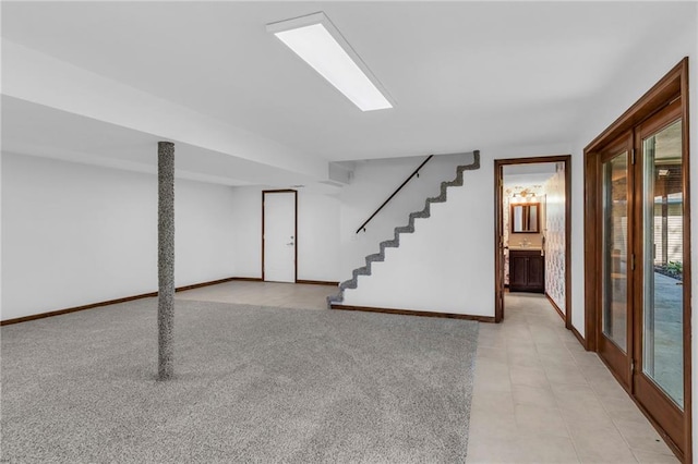 basement featuring baseboards and stairs