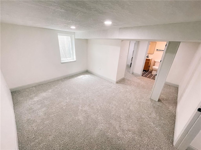 408 W 101st Ter, Kansas City, MO 64114 - basement featuring recessed lighting, a textured ceiling, light colored carpet, and baseboards