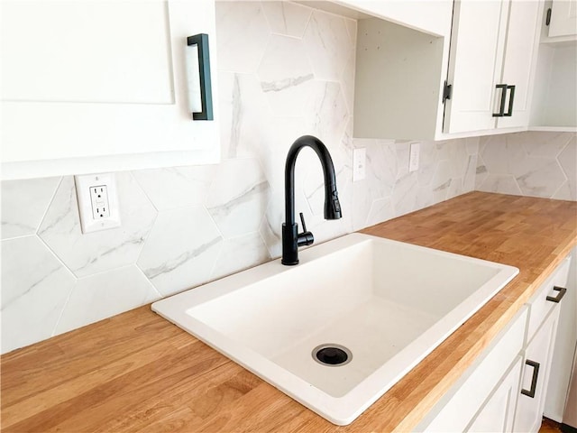 408 W 101st Ter, Kansas City, MO 64114 - room details with white cabinetry, a sink, and tasteful backsplash