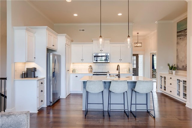 kitchen featuring appliances with stainless steel finishes, a sink, white cabinetry, light countertops, and crown molding