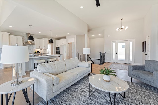 living area with light wood-type flooring, baseboards, recessed lighting, and a chandelier