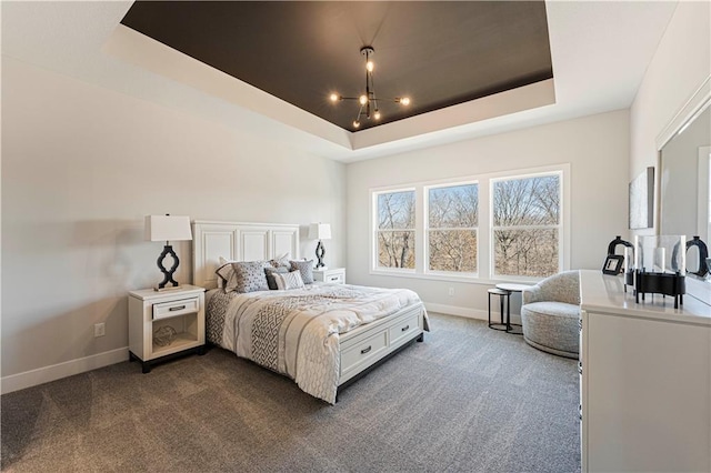 bedroom featuring baseboards, dark colored carpet, and a raised ceiling