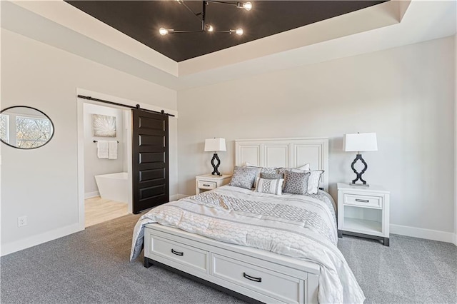 carpeted bedroom featuring a barn door, a chandelier, baseboards, and a tray ceiling