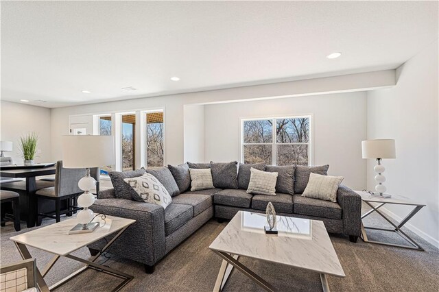 living area featuring recessed lighting, dark carpet, and a healthy amount of sunlight