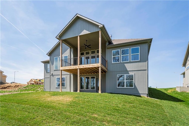 back of house with a lawn, a ceiling fan, and a balcony