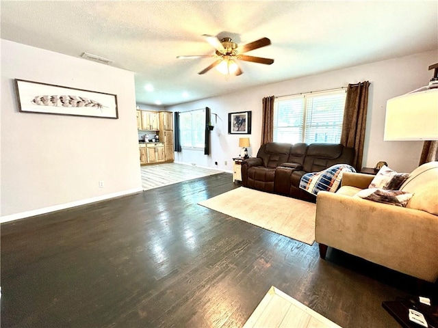 312 W Pine St, Butler, MO 64730 - living area featuring a ceiling fan, wood finished floors, and baseboards